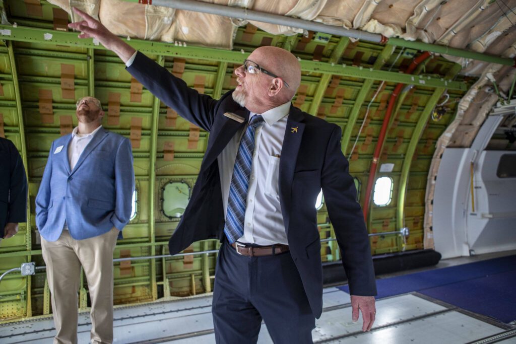 AMSC Executive Director Larry Cluphf points out specific aspects in a training area during a press conference and tour at the Washington Aerospace Training and Research Center on Wednesday, March 6, 2024 in Everett, Washington. (Annie Barker / The Herald)
