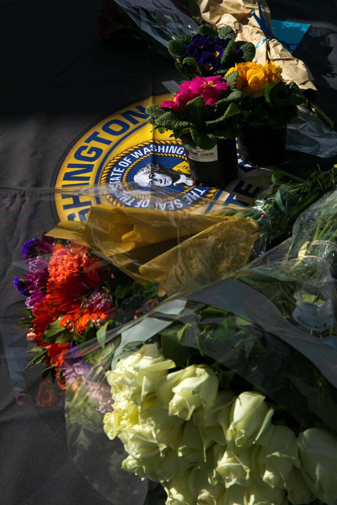 Flowers for slain trooper Chris Gadd begin to accumulate outside Washington State Patrol’s District 7 Headquarters on Saturday, March 2, 2024, in Marysville, Washington. (Ryan Berry / The Herald)
