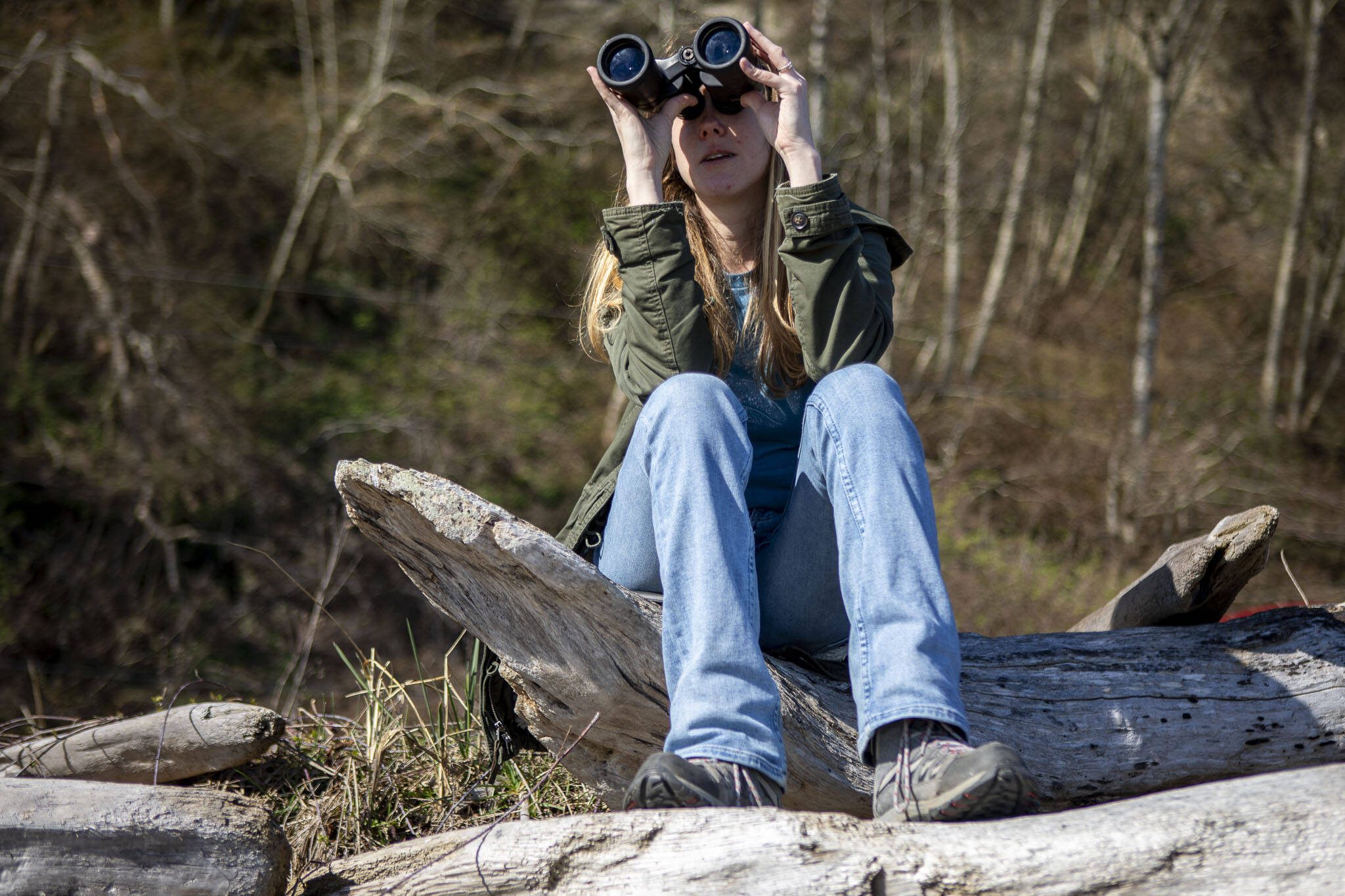 Rachel Haight from the Whale Sighting Network looks for gray and orca whales on Monday, March 18, 2024 at Hidden Beach in Greenbank, Washington. (Annie Barker / The Herald)