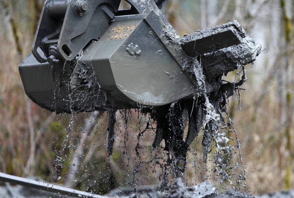 Heavy equipment moves debris on the western edge of the mudslide near Highway 530 on March 26, 2014 east of Oso, Washington. (Mark Mulligan / The Herald)
