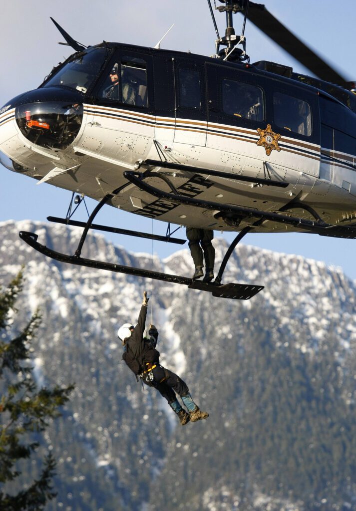 SnoHawk10 is pictured during search and rescue operations following a mudslide near Oso, Washington, on March 23, 2014. Crews lowered search and rescue workers into the slide area to retrieve bodies found in the mudslide. (Genna Martin / The Herald)
