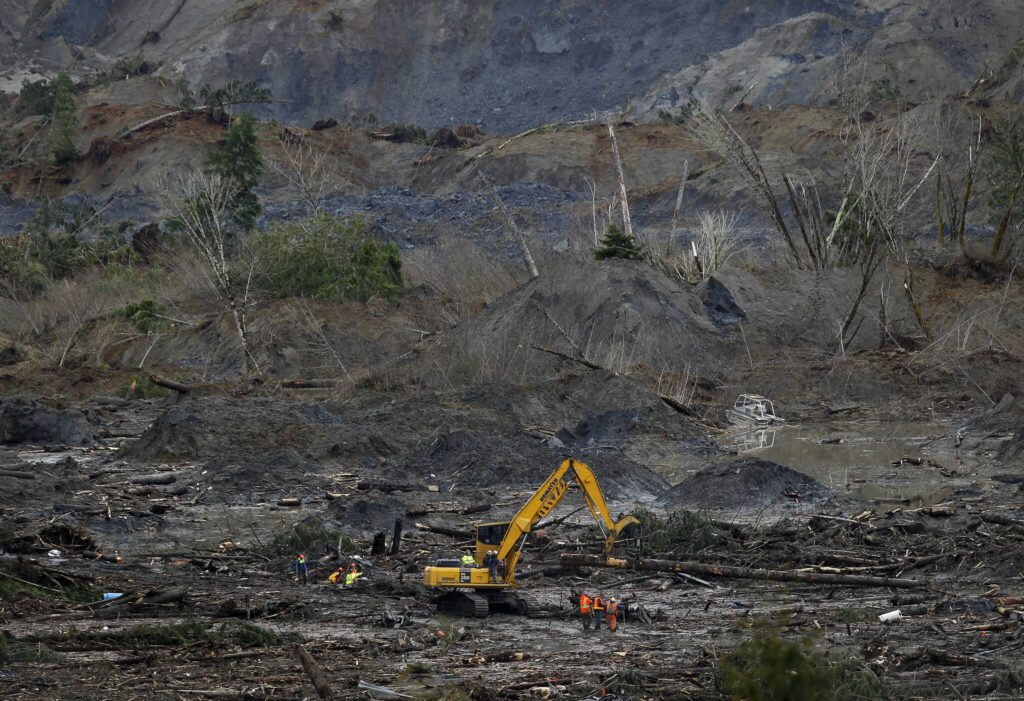 Rescue workers sift through the mud and debris at the Oso, Washington mudslide site on March 30, 2014. (Annie Mulligan / For The Herald)
