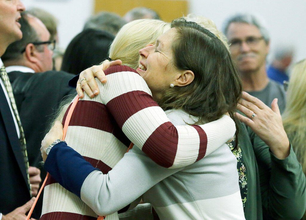 Corrie Yackulic, right, an attorney representing several family members of victims of the 2014 Oso landslide, hugs Lisa Bejvl, left, who lost her brother Alan in the slide, in King County Superior Court on Monday, Oct. 10, 2016, in Seattle, after it was announced that a settlement had been reached in a lawsuit brought by survivors and family members. (AP Photo/Ted S. Warren)
