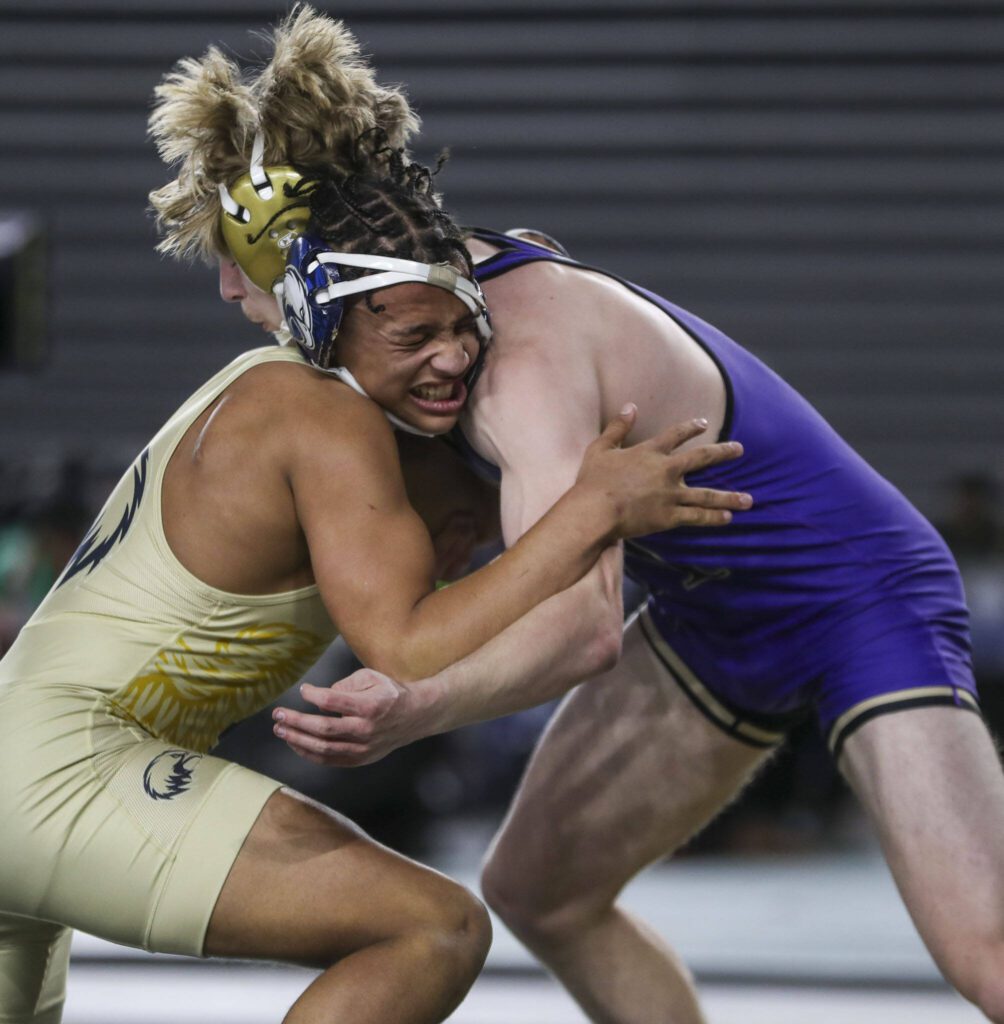 Arlington’s Tre Haines (left) wrestles Oak Harbor’s Percie Hatfield in the Class 3A boys 157-pound championship match during Mat Classic XXXV on Feb. 17 at the Tacoma Dome in Tacoma. (Annie Barker / The Herald)
