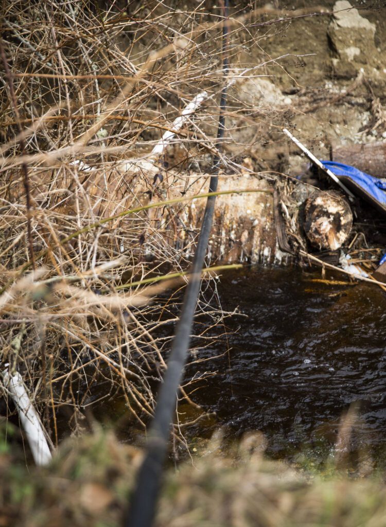 A temporary water line is string over the washed out road so resident can receive running water after their pipe was snapped by the washed out road on Wednesday, March 6, 2024 in Marysville, Washington. (Olivia Vanni / The Herald)
