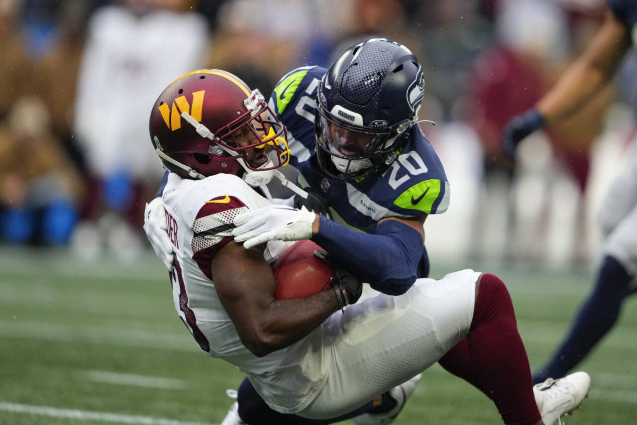 Seattle Seahawks safety Julian Love (20) makes a tackle during a game against the Washington Commanders on Nov. 12, 2023, in Seattle. Love figures to be the starter at one of the two safety spots next season. (AP Photo/Lindsey Wasson)