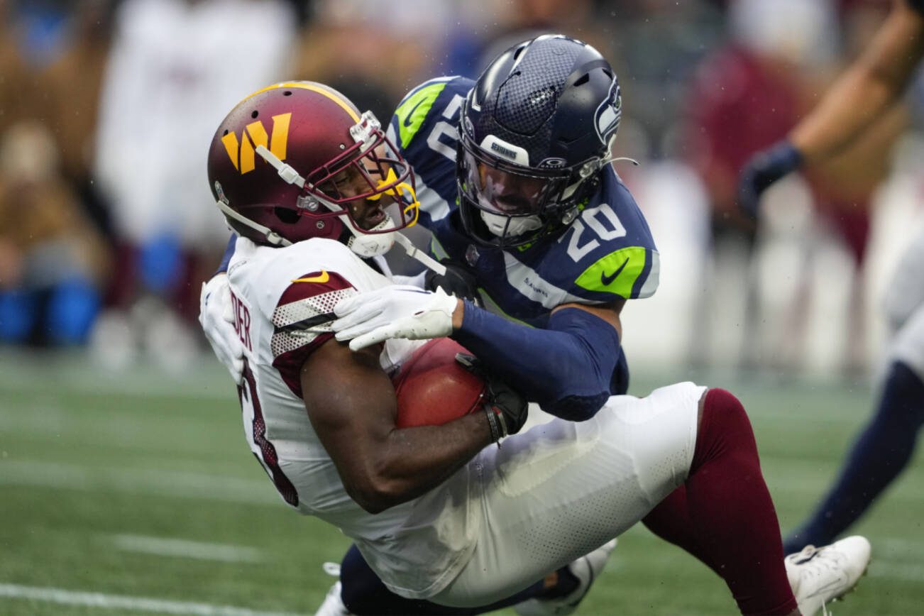 Seattle Seahawks safety Julian Love (20) tackles Washington Commanders running back Chris Rodriguez Jr. (23) in the first half of an NFL football game in Seattle, Sunday, Nov. 12, 2023. (AP Photo/Lindsey Wasson)
