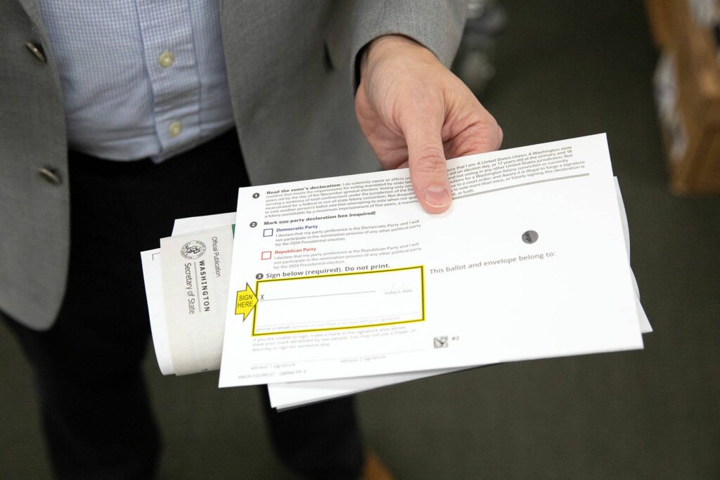 Snohomish County Auditor Garth Fell holds a sample ballot. “For most issues with a ballot, they are curable or resolvable,” he says. (Ryan Berry / The Herald)
