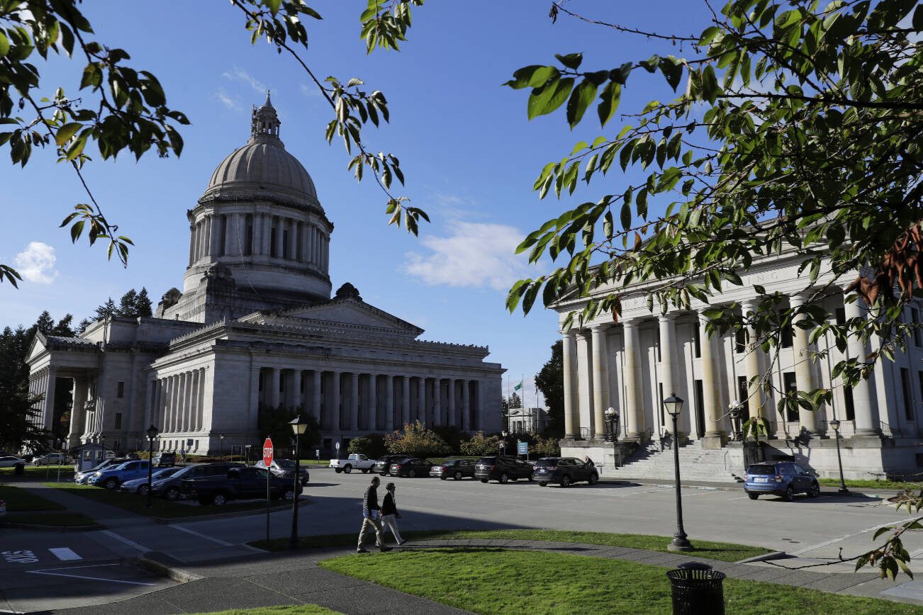 FILE - The afternoon sun illuminates the Legislative Building, left, at the Capitol in Olympia, Wash., Oct. 9, 2018. Three conservative-backed initiatives that would give police greater ability to pursue people in vehicles, declare a series of rights for parents of public-school students and bar an income tax were approved by the Washington state Legislature on Monday, March 4, 2024.   (AP Photo/Ted S. Warren, File)