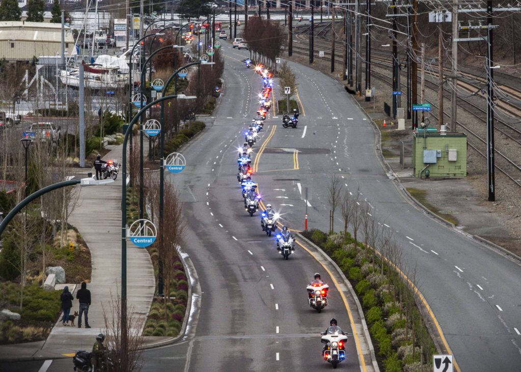 Washington State Patrol troopers on motorcycles ride down Marine View Drive in a memorial procession for fallen trooper Chris Gadd on Tuesday, March 12, 2024 in Everett, Washington. (Olivia Vanni / The Herald)
