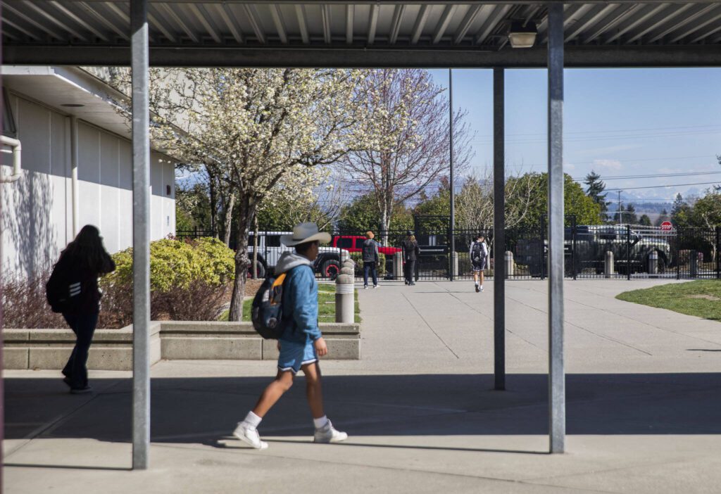 Students make their way through a portion of a secure gate and fence located only in the front of Lakewood Elementary School on Tuesday, March 19, 2024 in Marysville, Washington. Fencing the entire campus is something that would hopefully be upgraded with funds from the levy. (Olivia Vanni / The Herald)
