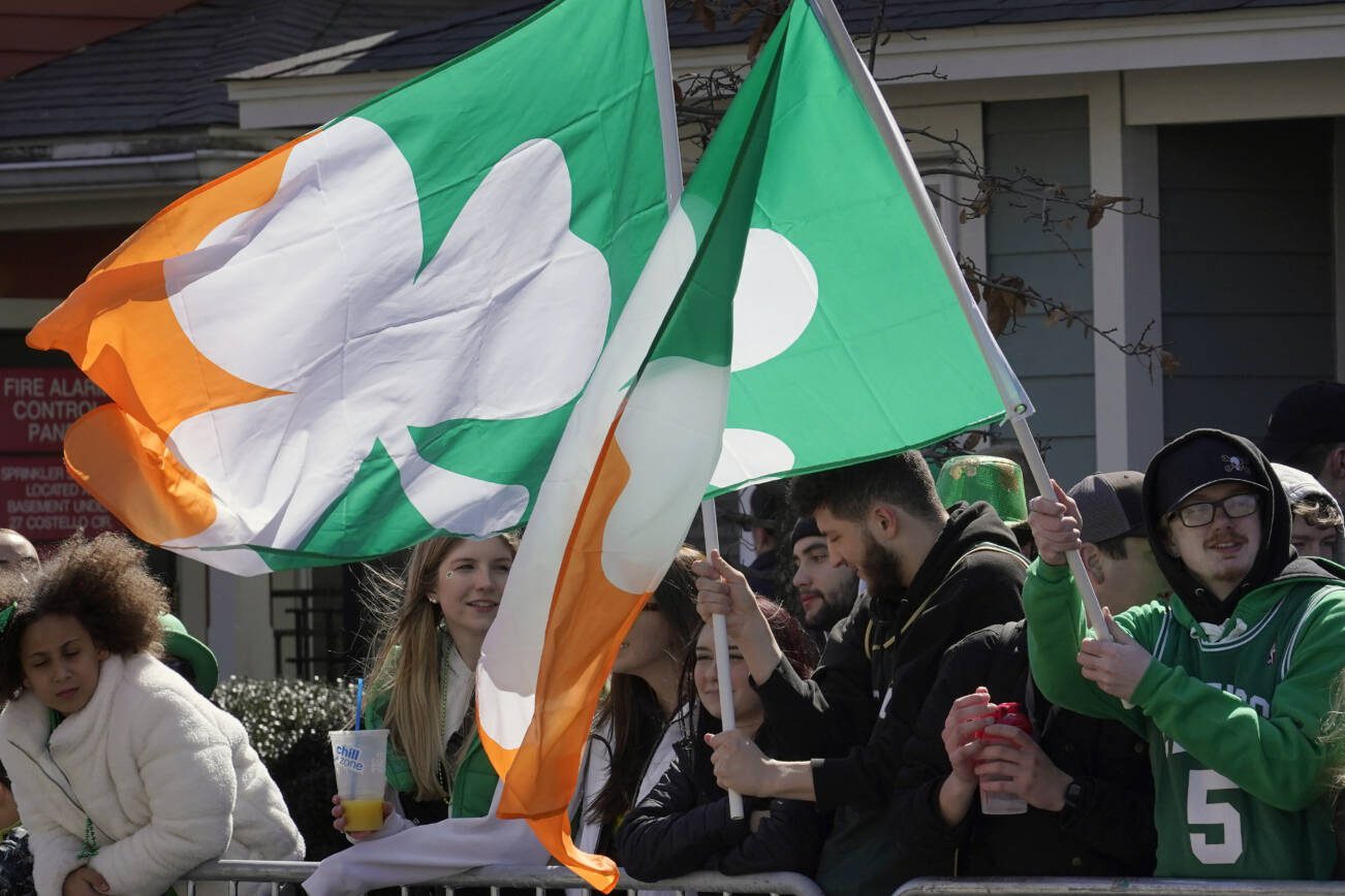 Spectators display flags while watching the annual St. Patrick's Day parade, Sunday, March 19, 2023, in Boston's South Boston neighborhood. (AP Photo/Steven Senne)