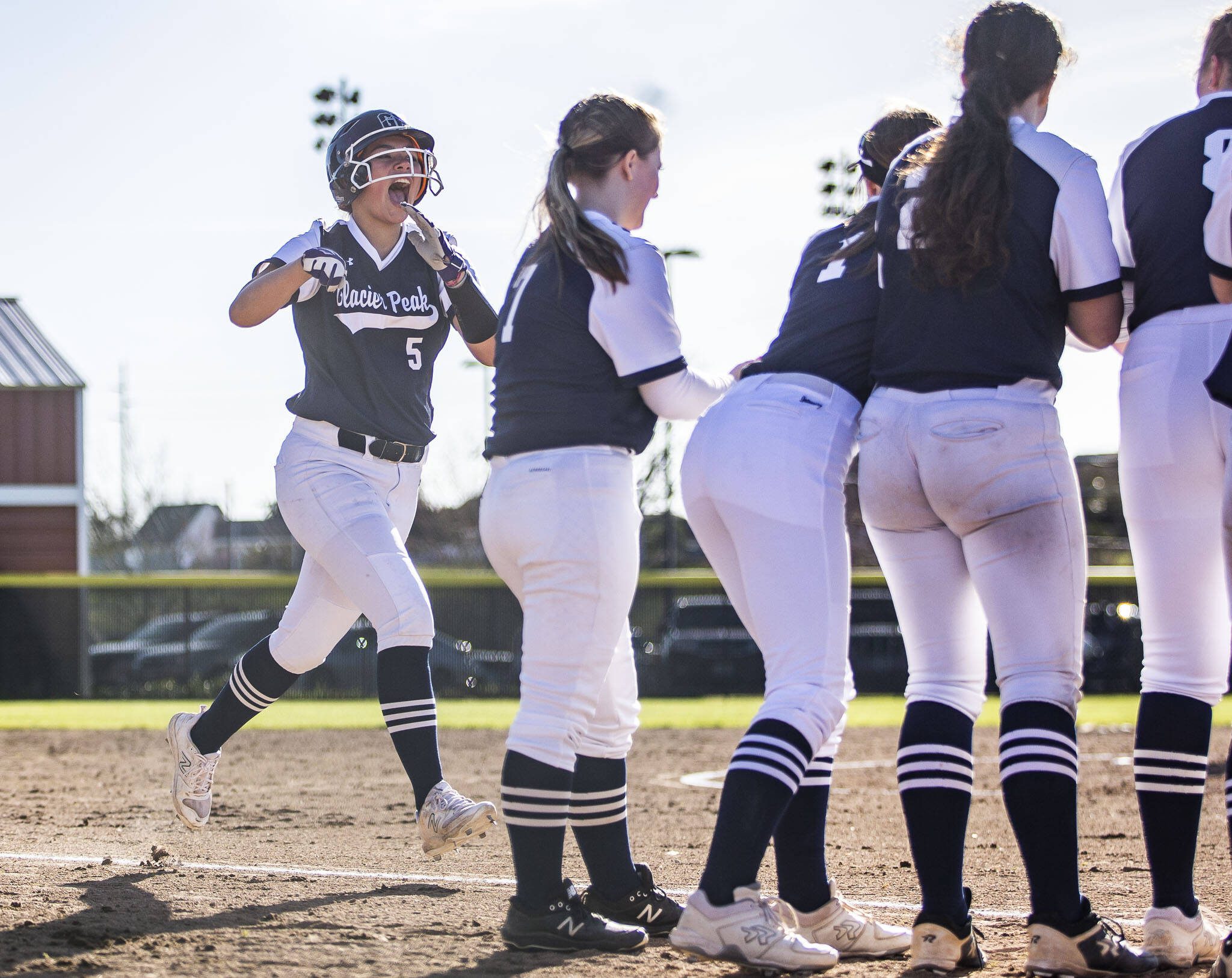 Glacier Peak’s Samantha Christensen runs to home plate to celebrate her home run with her teammates during the game against Snohomish on Friday, March 15, 2024 in Snohomish, Washington. (Olivia Vanni / The Herald)