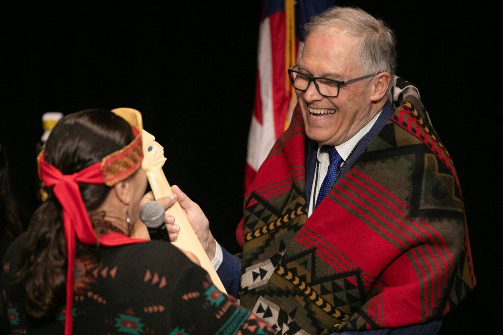 Tulalip Chair Teri Gobin presents Gov. Jay Inslee with a war club after a slew of bill-signings on Tuesday, March 19, 2024, at Tulalip Casino’s Orca Ballroom in Tulalip, Washington. (Ryan Berry / The Herald)
