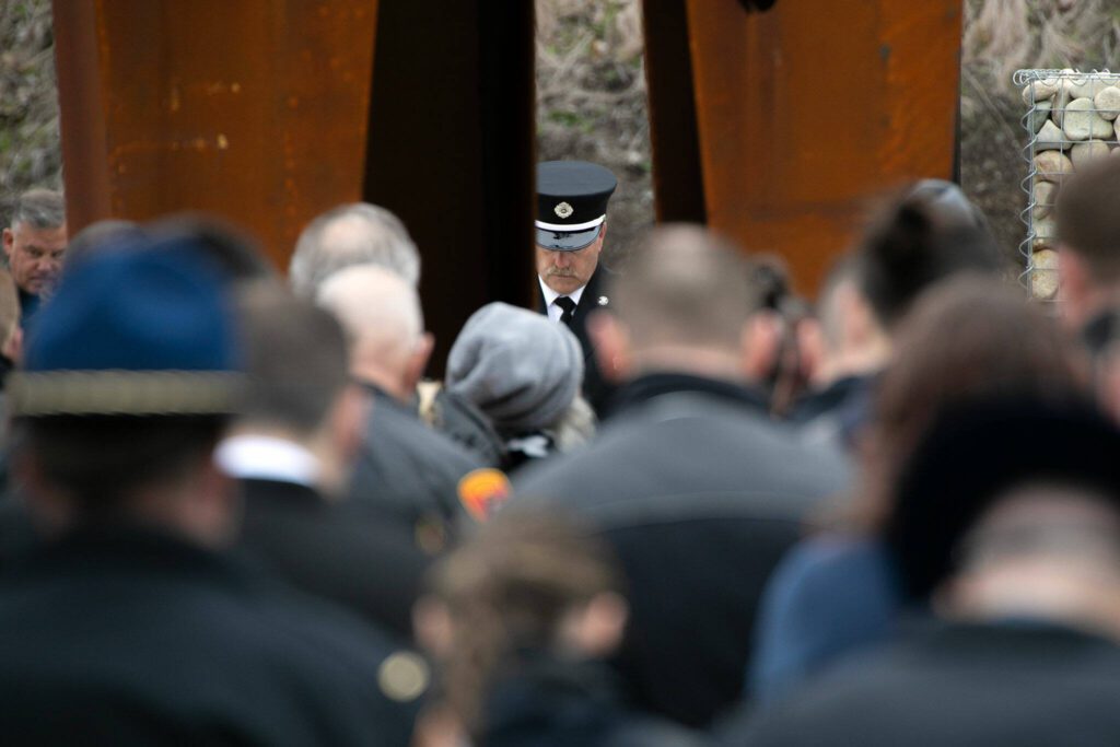 People bow their heads in prayer at the conclusion of the ten-year remembrance of the Oso landslide on Friday, March 22, 2024, at the Oso Landslide Memorial in Oso, Washington. (Ryan Berry / The Herald)
