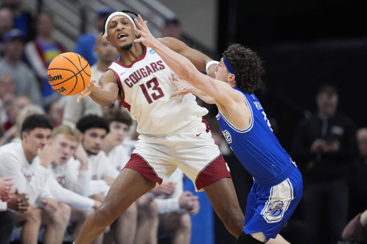 Washington State’s Isaac Jones passes around Drake’s Conor Enright during the second half of an NCAA Tournament game Thursday in Omaha, Neb. (AP Photo/Charlie Neibergall)