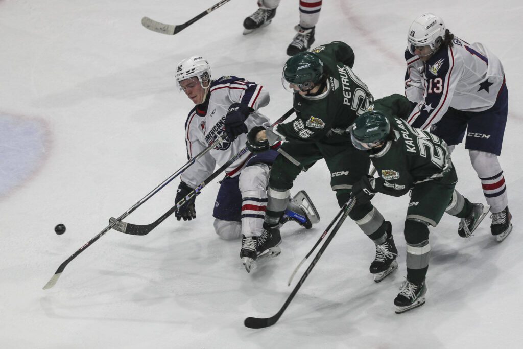 Silvertips’ Andrew Petruk (26) fights for the puck during a game against the Tri-City Americans at the Angel of the Winds Arena on Sunday in Everett. (Annie Barker / The Herald)
