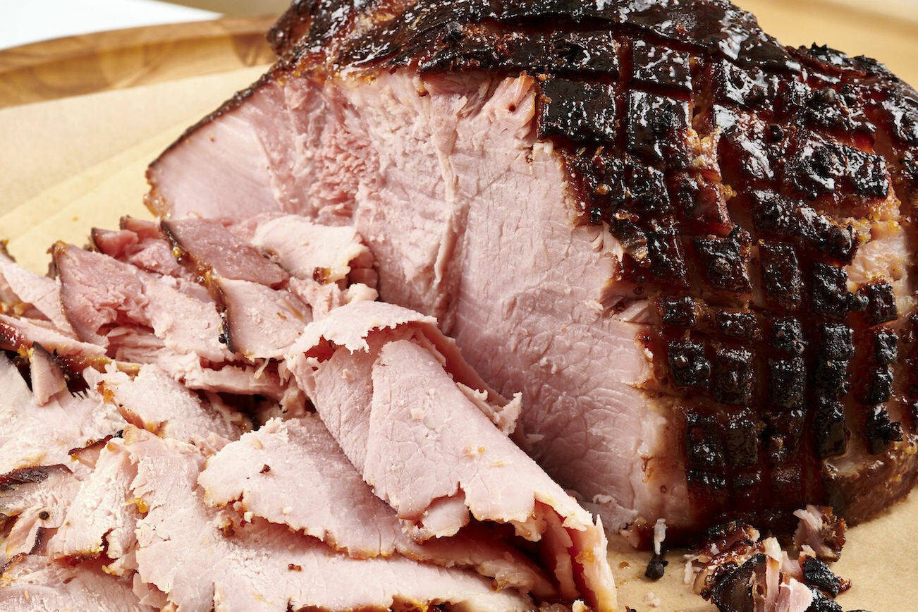 This September 2020 photo shows a sliced baked ham on parchment paper in Washington, D.C. Leftover ham, which will last for up to five days in the fridge, can be a springboard for other meals during the week. Of course you’ll want a sandwich or two, but there are many other ways to put that porky, smoky flavor to good use. (Cheyenne Cohen via AP)