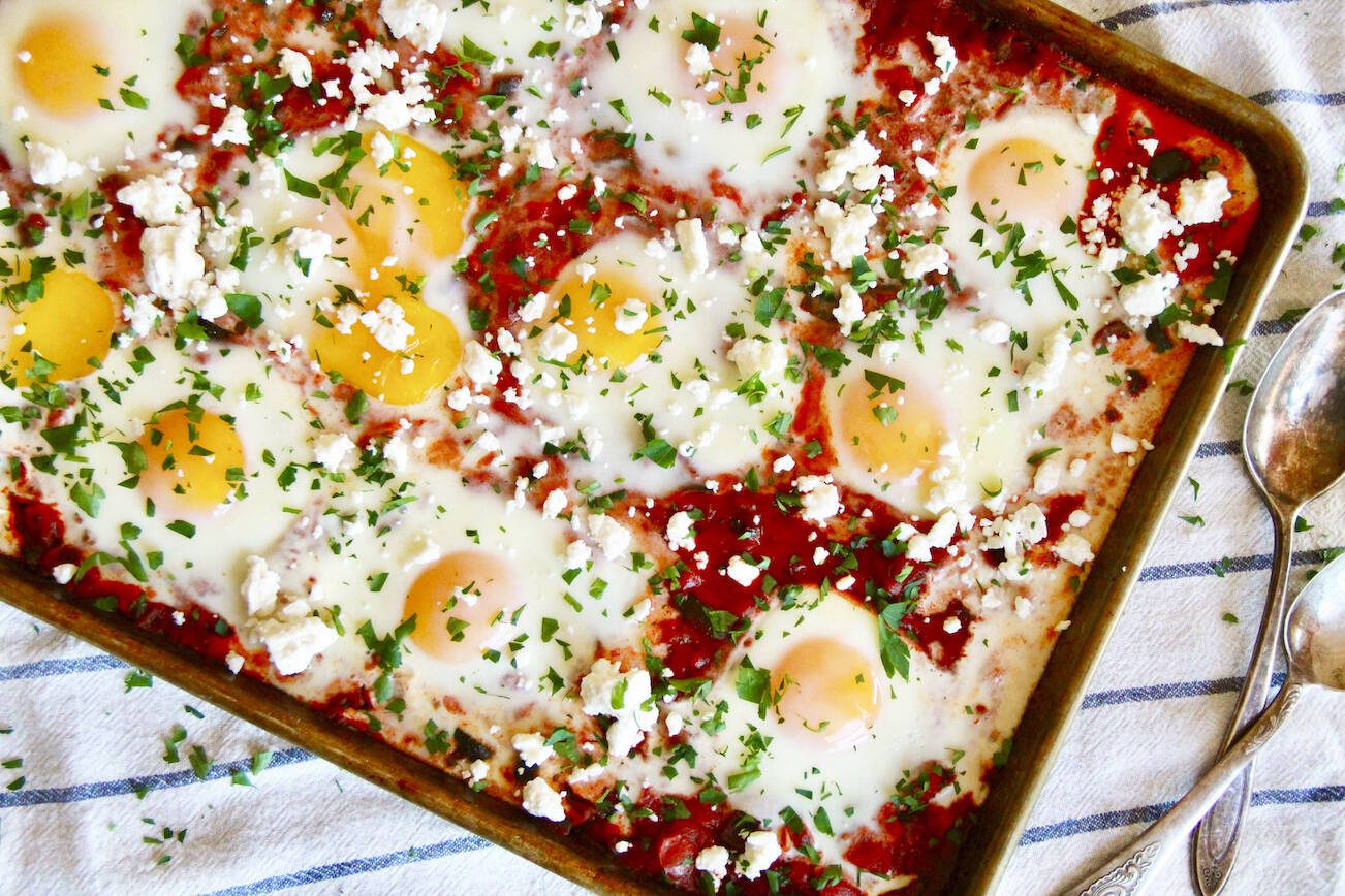 This image shows a larger adaptation of the Israeli dish shakshuka from Molly Gilbert's "Sheet Pan Suppers." (Molly Gilbert via AP)