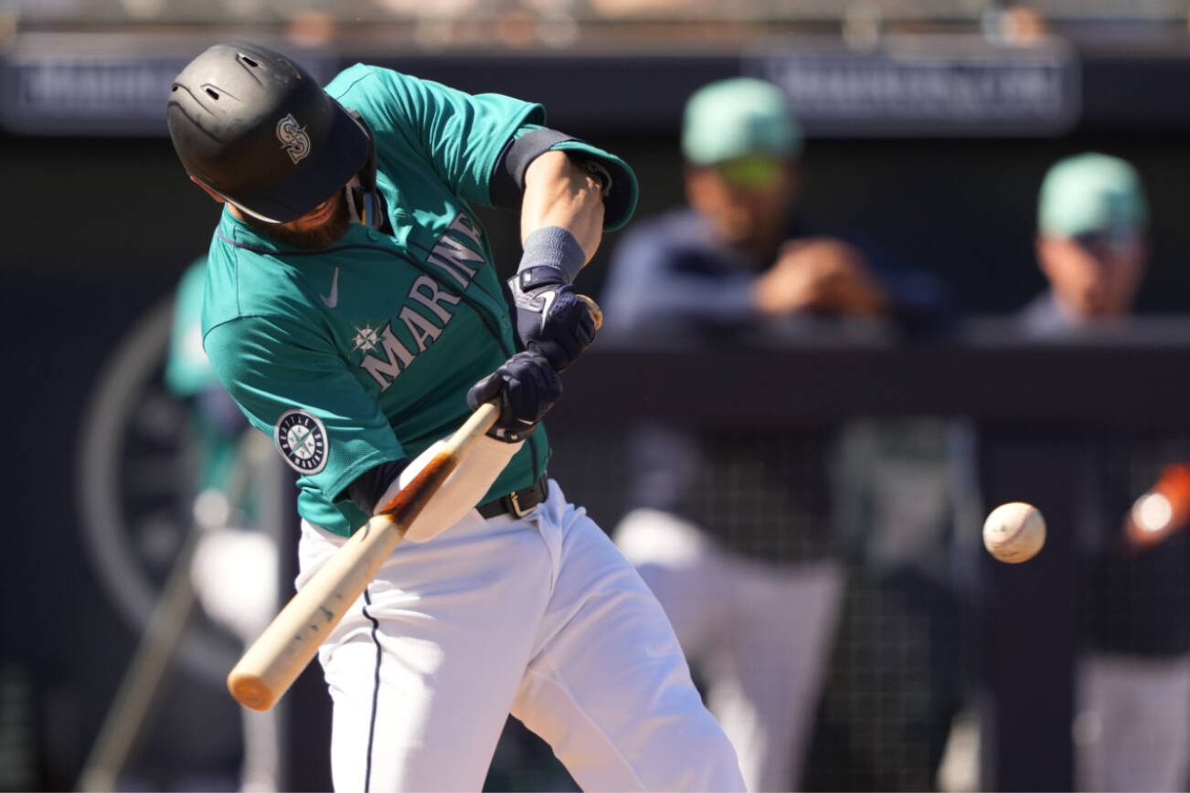 Seattle Mariners' Mitch Haniger hits a single against the San Diego Padres during the fourth inning of a spring training baseball game Monday, March 11, 2024, in Peoria, Ariz. (AP Photo/Lindsey Wasson)