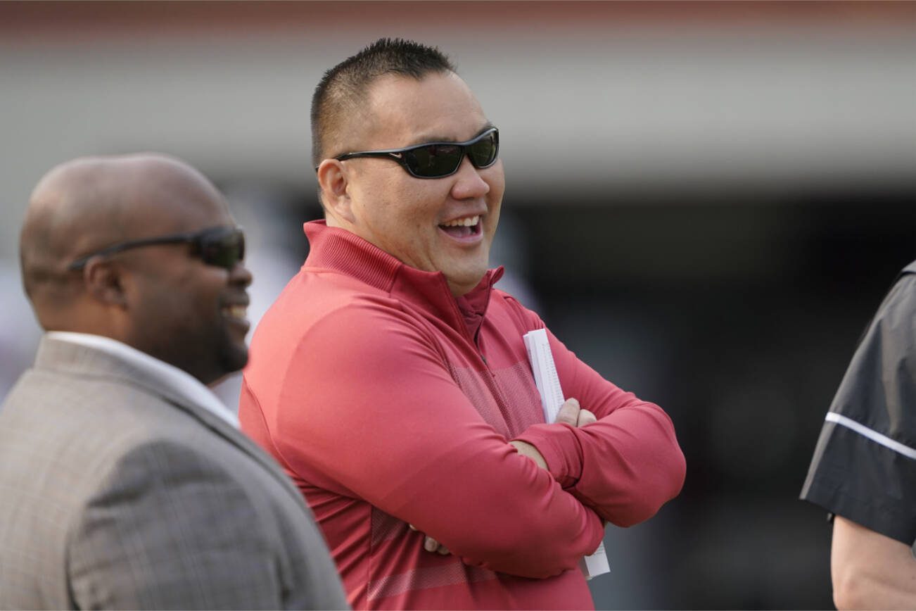Washington State athletic director Pat Chun, center, watches players on the first day of NCAA college football practice, Friday, Aug. 6, 2021, in Pullman, Wash. (AP Photo/Ted S. Warren)