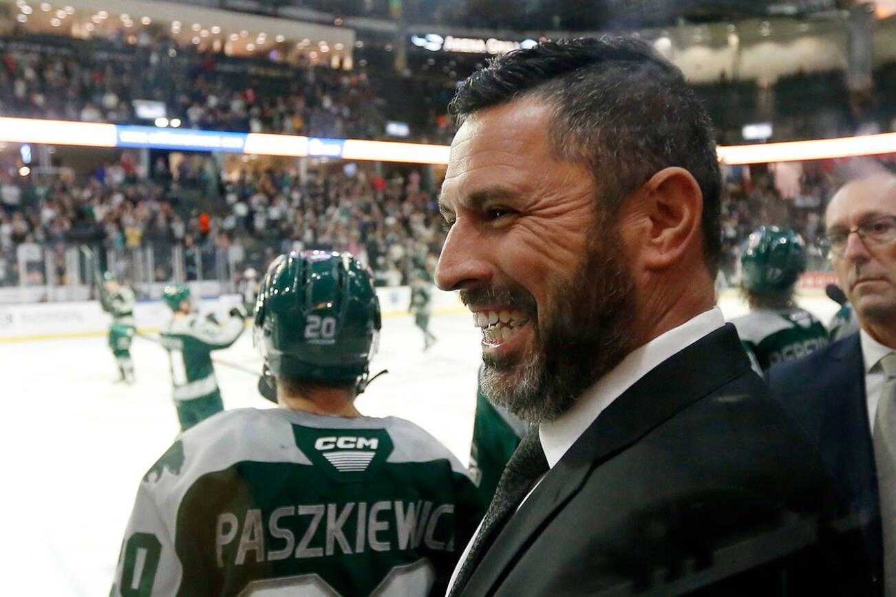Dennis Williams, head coach and GM of the Everett Silvertips, shakes hands with an assistant coach at the end of a season opening victory over the Vancouver Giants on Saturday, Sep. 24, 2022, at Angel of the Winds Arena in Everett, Washington. (Ryan Berry / The Herald)