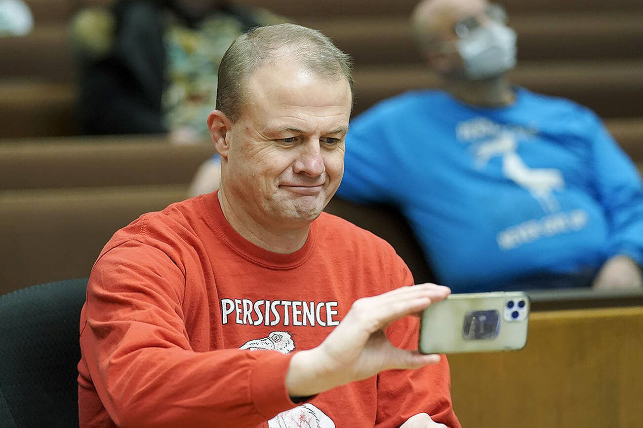 Initiative promoter Tim Eyman takes a selfie photo before the start of a session of Thurston County Superior Court, Wednesday, Feb. 10, 2021, in Olympia, Wash. Eyman, who ran initiative campaigns across Washington for decades, will no longer be allowed to have any financial control over political committees, under a ruling from Superior Court Judge James Dixon Wednesday that blasted Eyman for using donor's contributions to line his own pocket. Eyman was also told to pay more than $2.5 million in penalties. (AP Photo/Ted S. Warren)