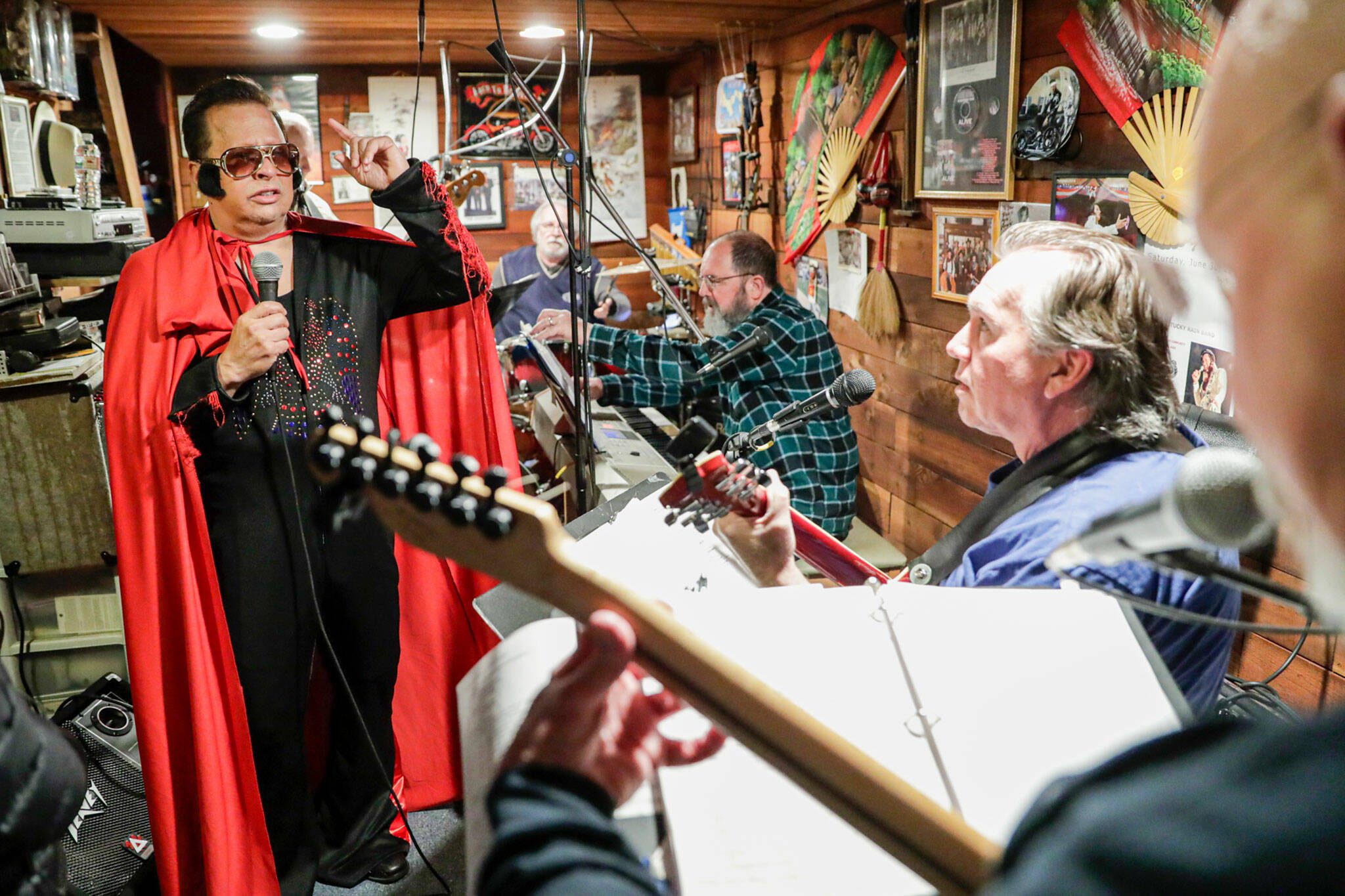 Gus Mansour works through timing with Kentucky Rain Band members Jeff Olson and Steven Preszler, far right, during a rehearsal for the Elvis Challenge in Everett on April 13, 2022. (Kevin Clark / The Herald)