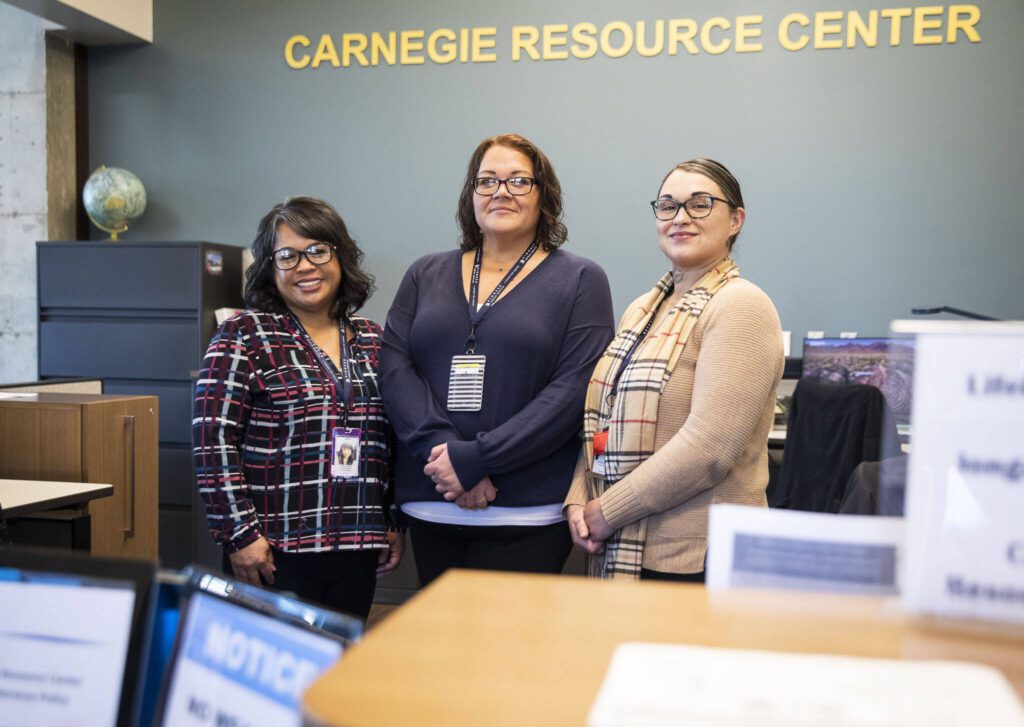 Carnegie Resource Center’s Shantel Harris, Rebecca Nelson and Brittany Brenon (left to right) at the center on Friday, Feb. 16, 2024 in Everett, Washington. (Olivia Vanni / The Herald)
