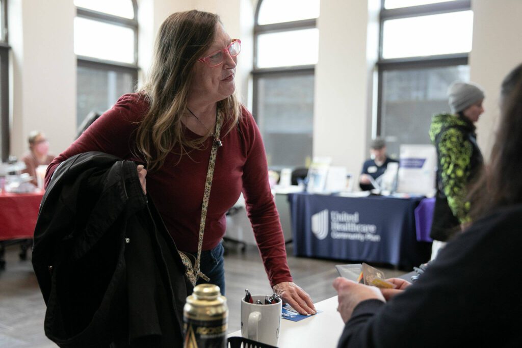 Marcella Wannquist collects a QFC gift card she won during a resource fair at the Carnegie Resource Center on Wednesday, March 6, 2024, in downtown Everett, Washington. (Ryan Berry / The Herald)
