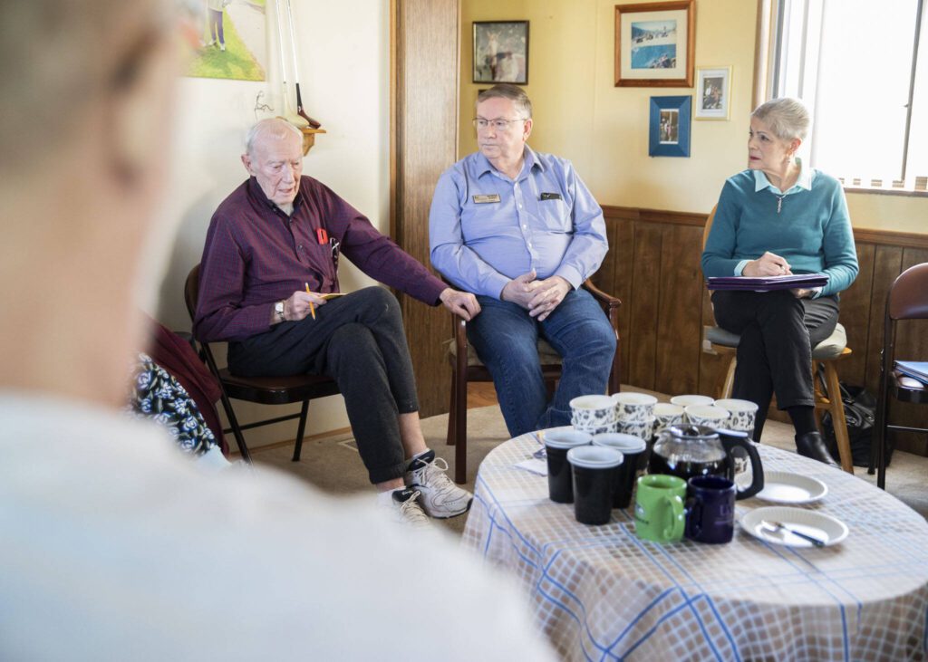 Royalwood Estates Mobile Home Park resident Victor Huff, left, speaks to Lynnwood City Council President George Hurst, center, about his concerns with the mobile home park rent being raised on Tuesday, March 5, 2024 in Lynnwood, Washington. (Olivia Vanni / The Herald)
