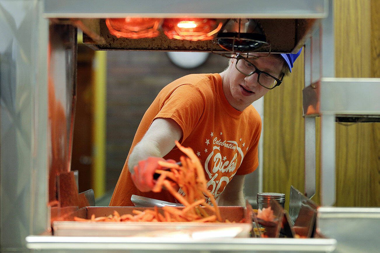 FILE - In this April 17, 2014 photo, Ryan Peterson prepares french fries at a Dick’s Drive-In restaurant in Seattle. The Institute for Supply Management, a group of purchasing managers, issues its index of non-manufacturing activity for April on Monday, May 5, 2014. (AP Photo/Ted S. Warren, File)