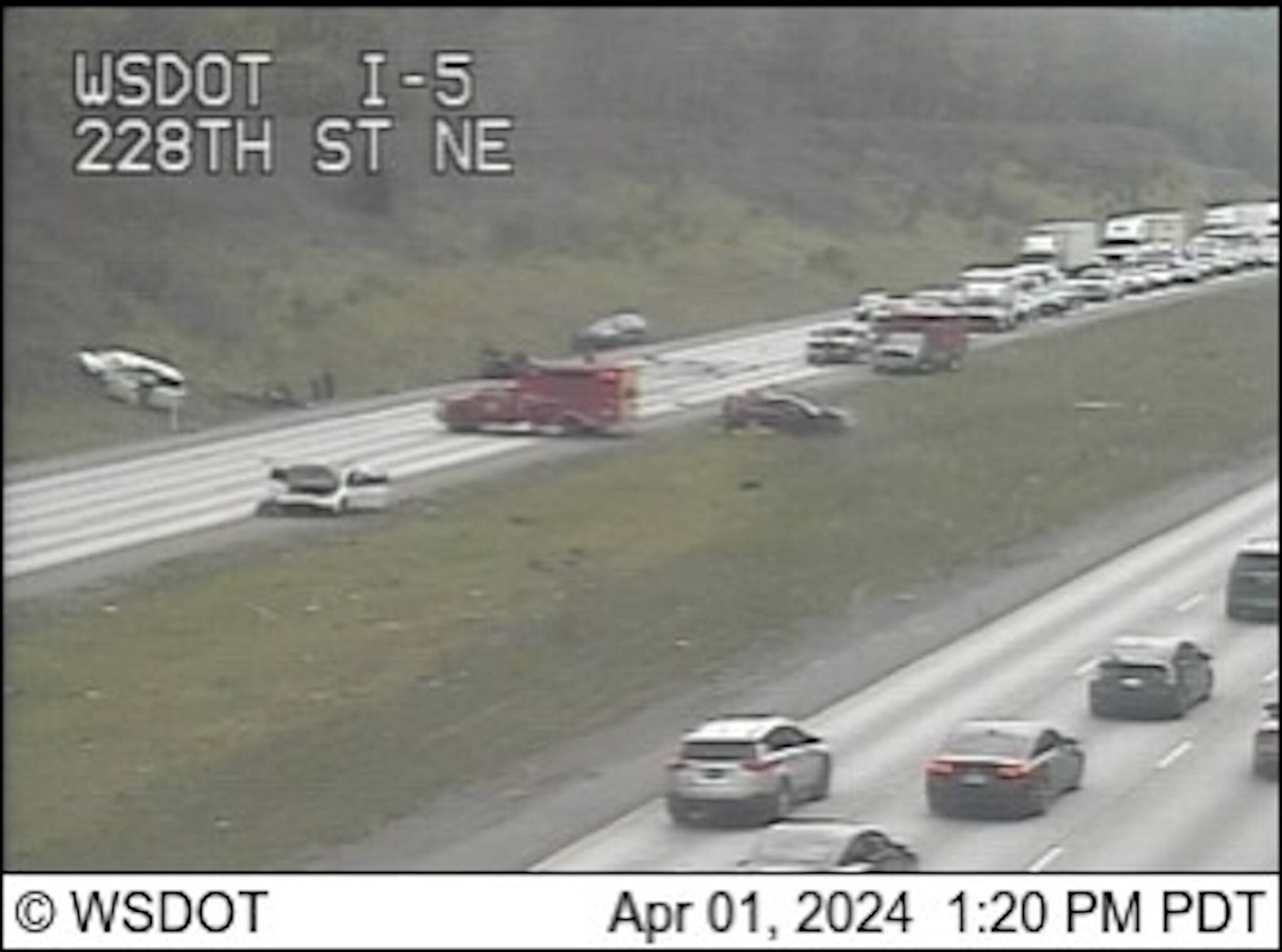 Traffic camera footage shows a crash on northbound I-5 near Arlington that closed all lanes of the highway Monday afternoon. (Washington State Department of Transportation)