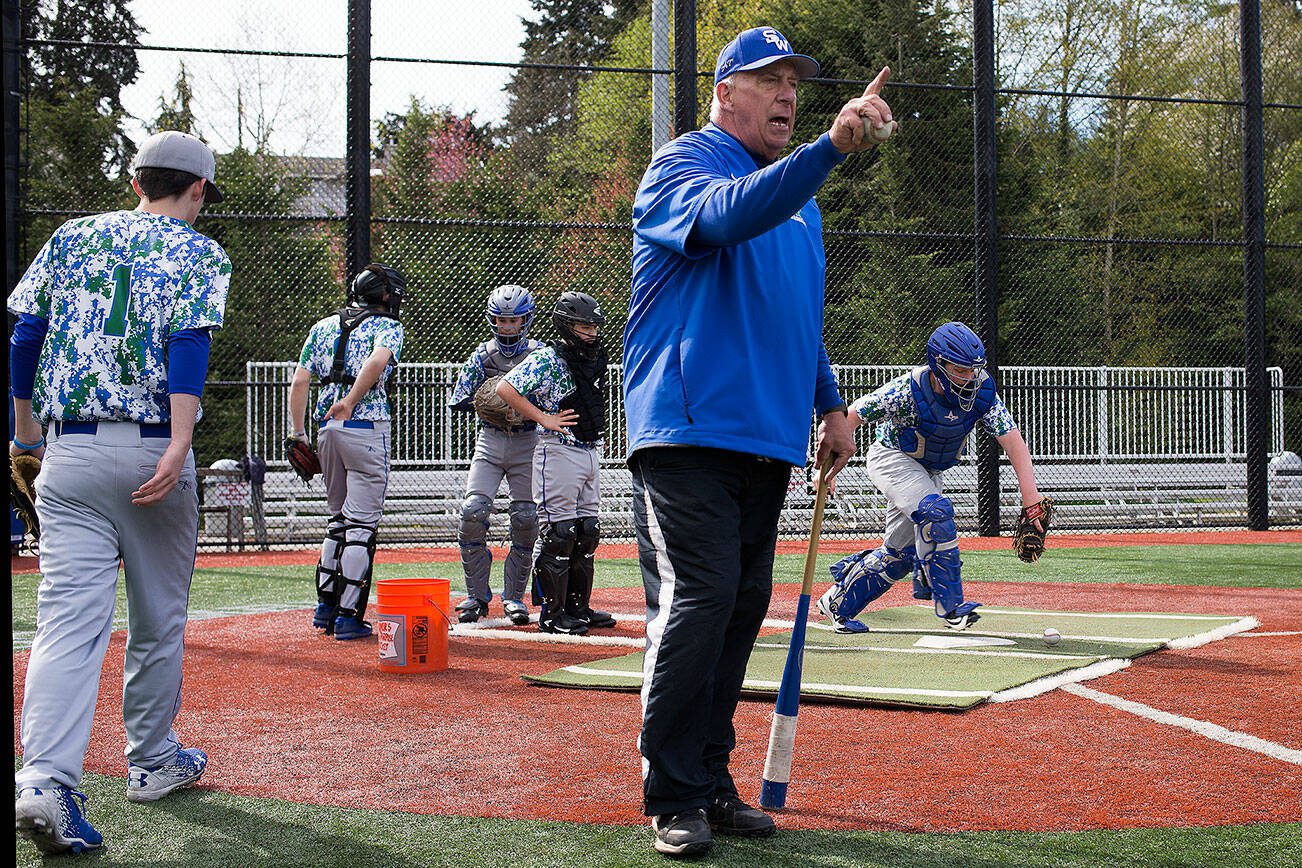 Shorewood baseball coach Wyatt Tonkin gives advice to a player in the infield as catchers practice behind him in 2017. (Andy Bronson / The Herald)