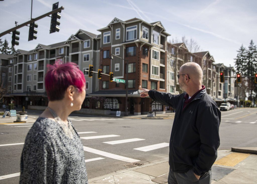 City Manager Jeff Niten, right, and Mountlake Terrace Mayor Kyoko Matsumoto Wright, left, talks about new housing built in the Town Center on Wednesday, April 10, 2024 in Mountlake Terrace, Washington. (Olivia Vanni / The Herald)
