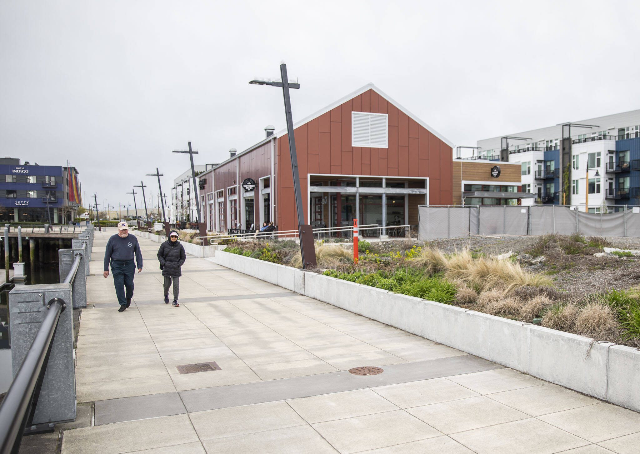 People walk along the waterfront in front of South Fork Bakery at the Port of Everett on Thursday, April 11, 2024 in Everett, Washington. (Olivia Vanni / The Herald)