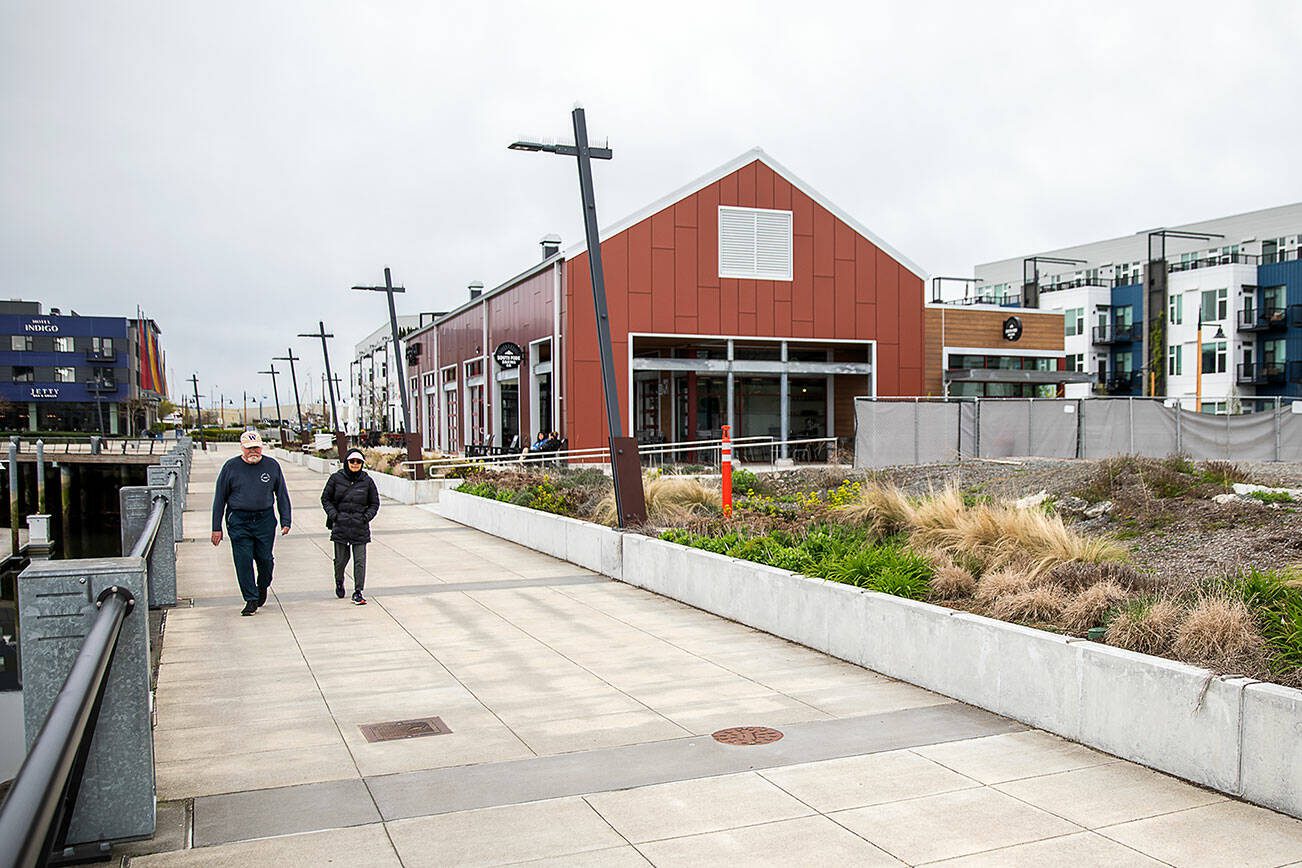 People walk along the waterfront in front of South Fork Bakery at the Port of Everett on Thursday, April 11, 2024 in Everett, Washington. (Olivia Vanni / The Herald)
