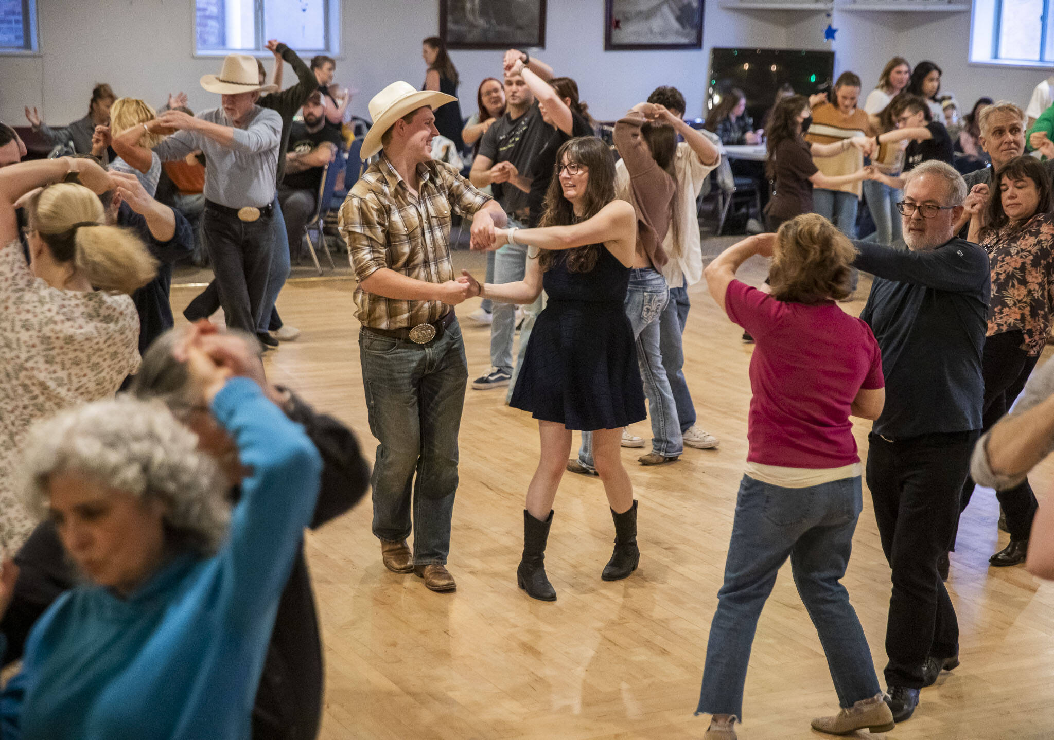 Matt Stewart, left, and Janice Ayala, right, spin during country dance lessons at Normanna Lodge on Tuesday, April 9, 2024 in Everett, Washington. Normanna Lodge will be hosting country dance next Tuesday during PBR Stampede. (Olivia Vanni / The Herald)