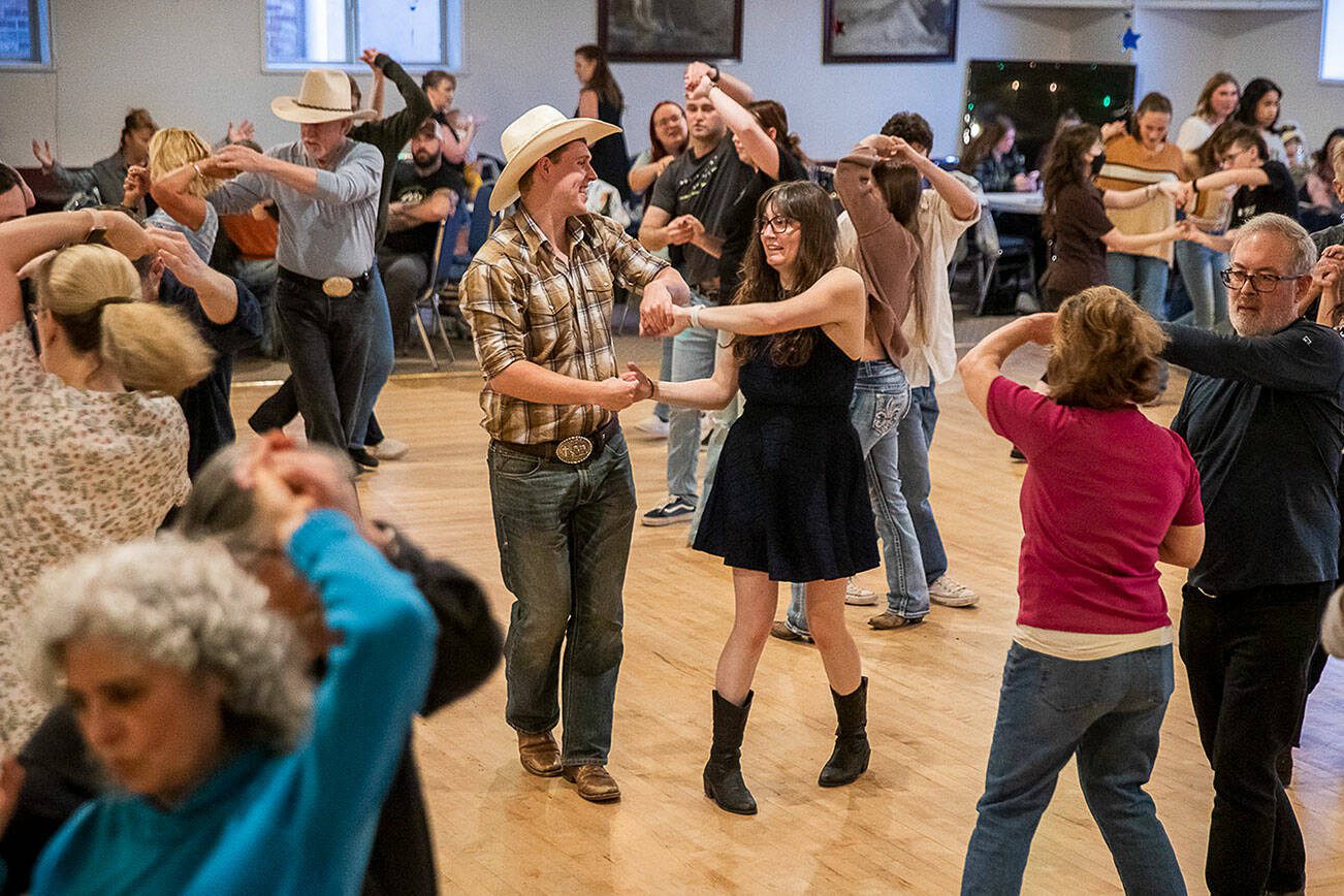 Matt Stewart, left, and Janice Ayala, right, spin during country dance lessons at Normanna Lodge on Tuesday, April 9, 2024 in Everett, Washington. Normanna Lodge will be hosting country dance next Tuesday during PBR Stampede. (Olivia Vanni / The Herald)
