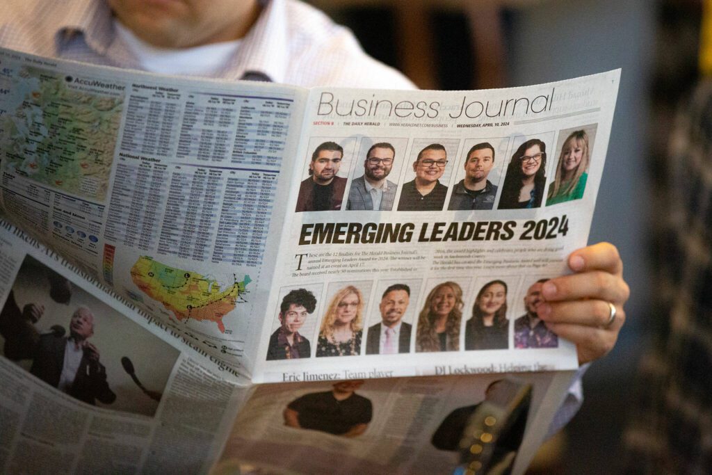 An attendee reads the Herald Business Journal during the 2024 Snohomish County Emerging Leaders Awards Presentation on Wednesday, April 17, 2024, in Everett, Washington. (Ryan Berry / The Herald)
