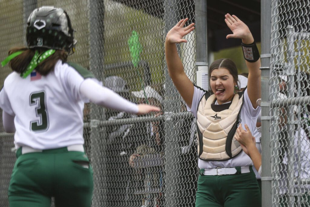Jackson players celebrate Addi Bale (3) scoring a run during a 4A softball game between Kamiak and Jackson at Kamiak High School on Tuesday, April 9, 2024 in Mukilteo, Washington. Jackson won, 9-0. (Annie Barker / The Herald)
