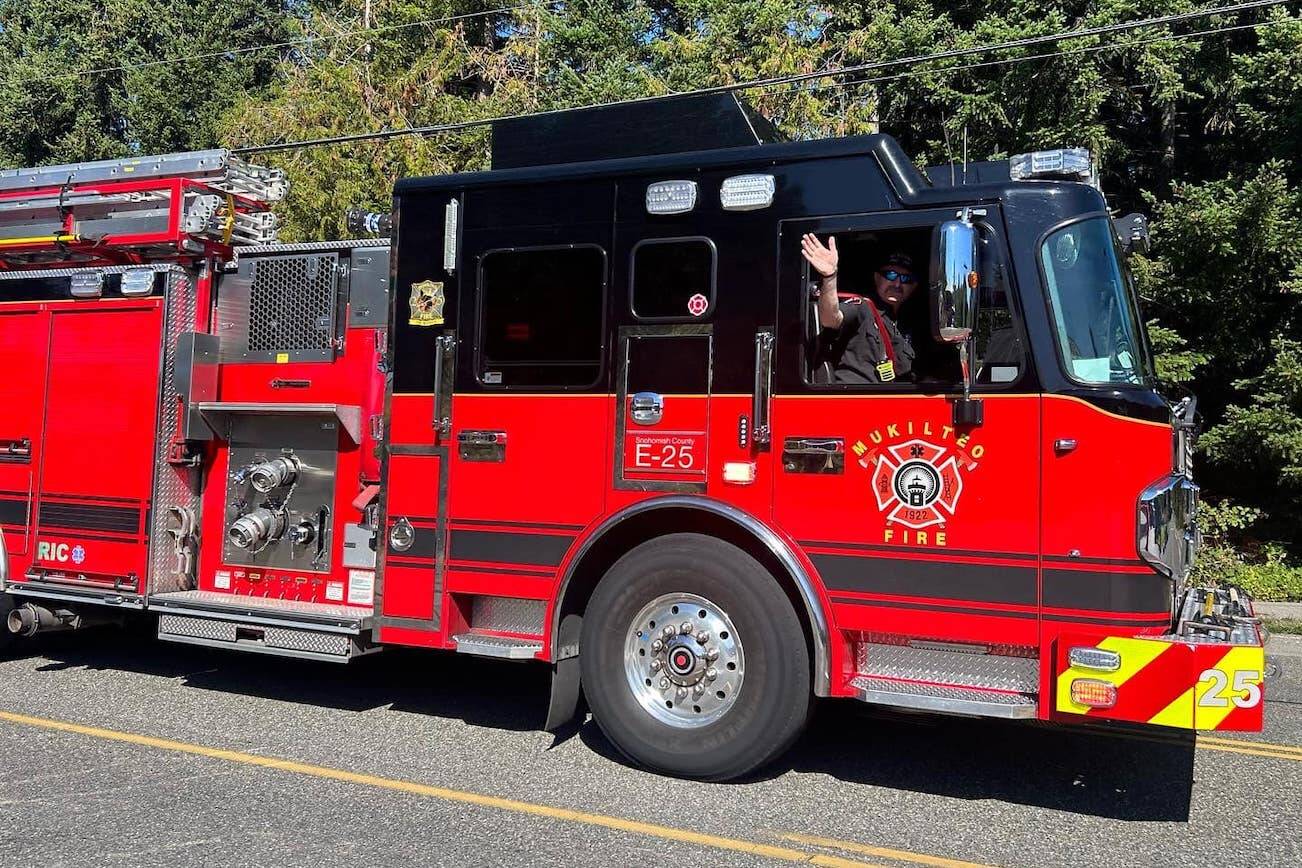 A Mukilteo firefighter waves out of a fire truck. (Photo provided by Mukilteo Fire Department)