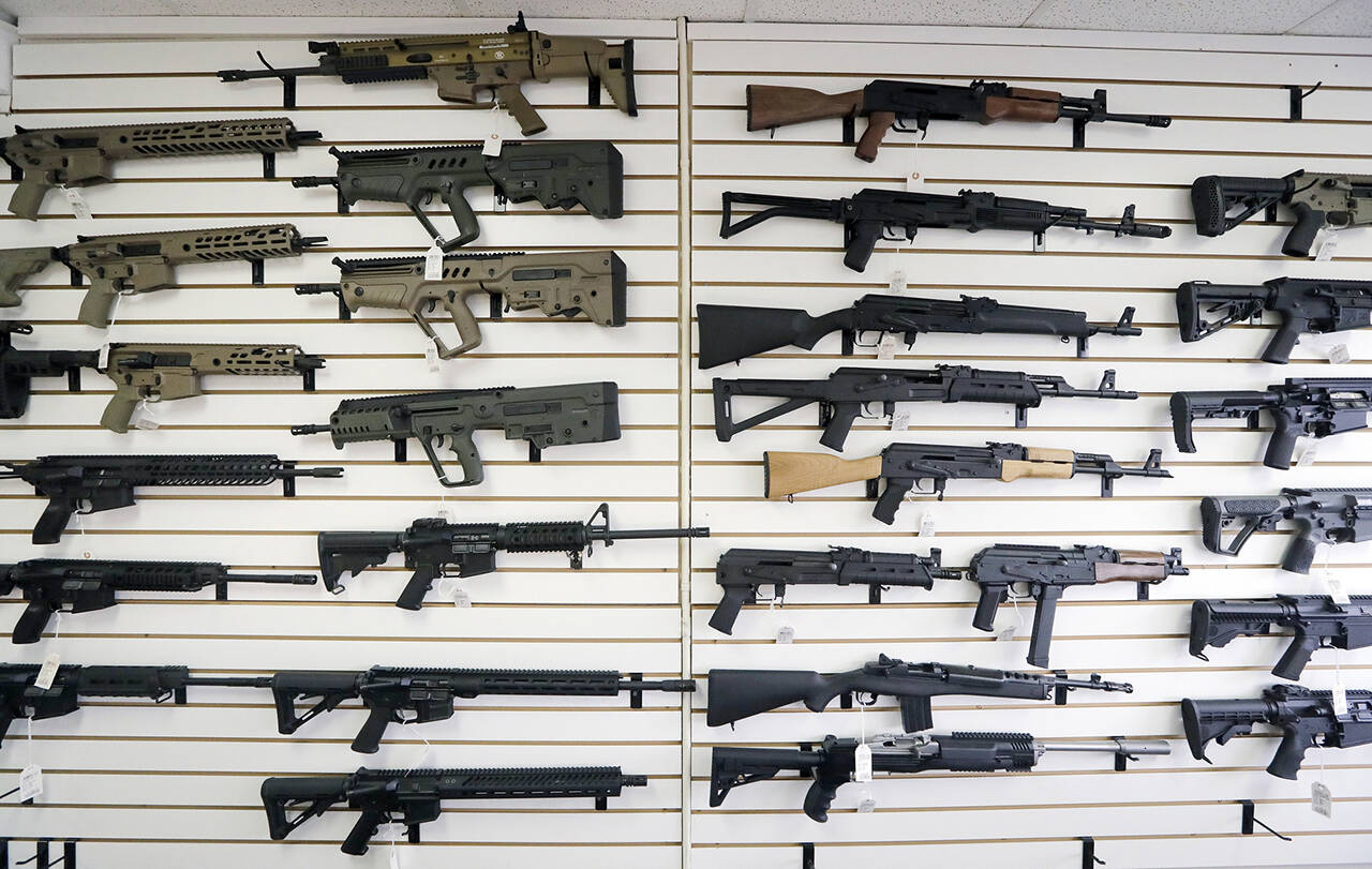 Semi-automatic rifles fill a wall of a gun shop in Lynnwood, in October 2018. (Elaine Thompson / Associated Press file photo)