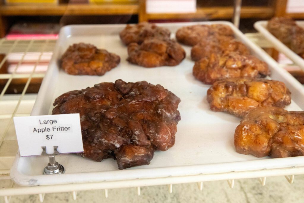 A giant apple fritter puts to shame the regular-size ones on Wednesday, April 17, 2024, at Karl’s Bakery in Everett, Washington. (Ryan Berry / The Herald)

