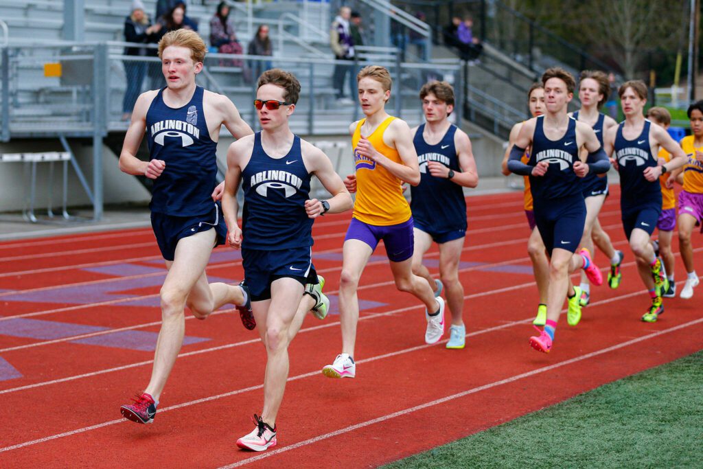Arlington’s Lucas Spurling, left, and Grady Fournier take an early lead in the 3200 during a meet Thursday, April 11, 2024, in Lake Stevens, Washington. Fournier won the race, and Spurling took third, with Lake Stevens’ Owen Stults taking second place. (Ryan Berry / The Herald)
