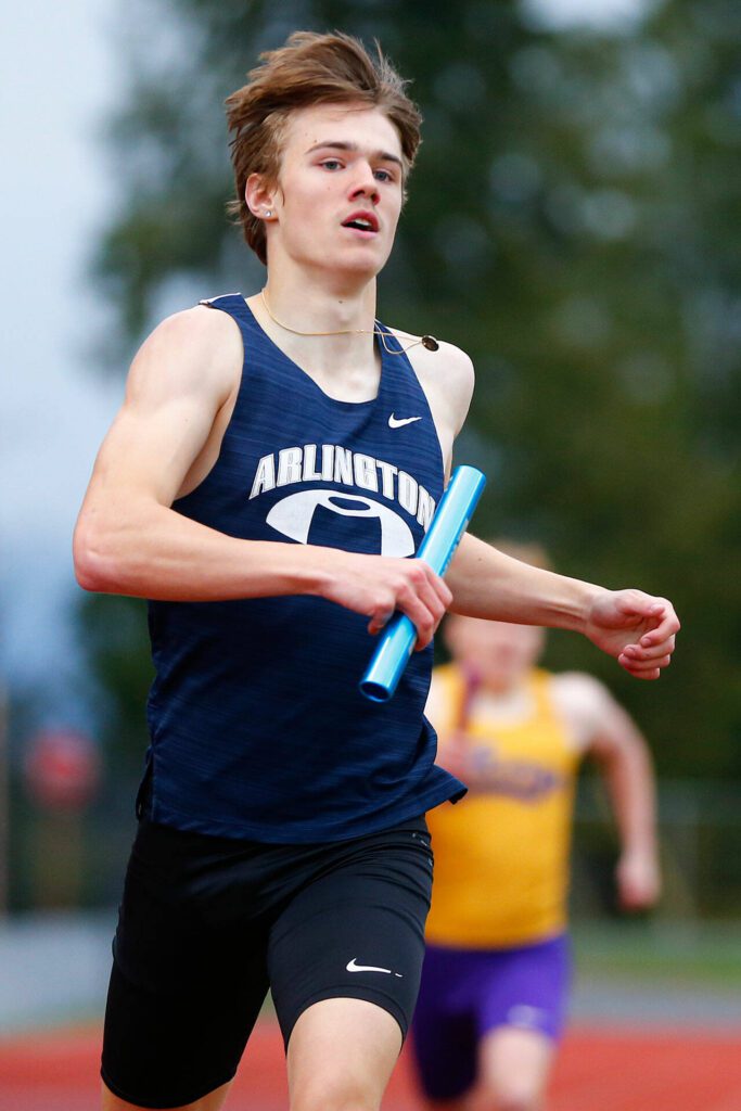 Arlington anchor Dallas Miller finishes victorious in the 4×400 during a meet Thursday, April 11, 2024, in Lake Stevens, Washington. (Ryan Berry / The Herald)

