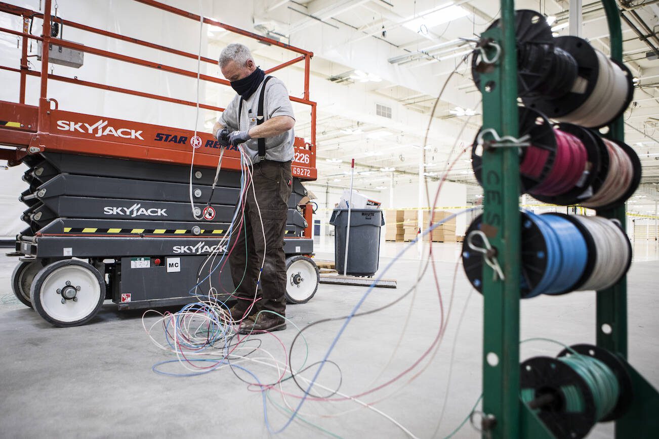 Pat Clayton works on putting in electrical wiring at the new Helion headquarters on Wednesday, Jan. 19, 2022 in Everett, Washington. (Olivia Vanni / The Herald)