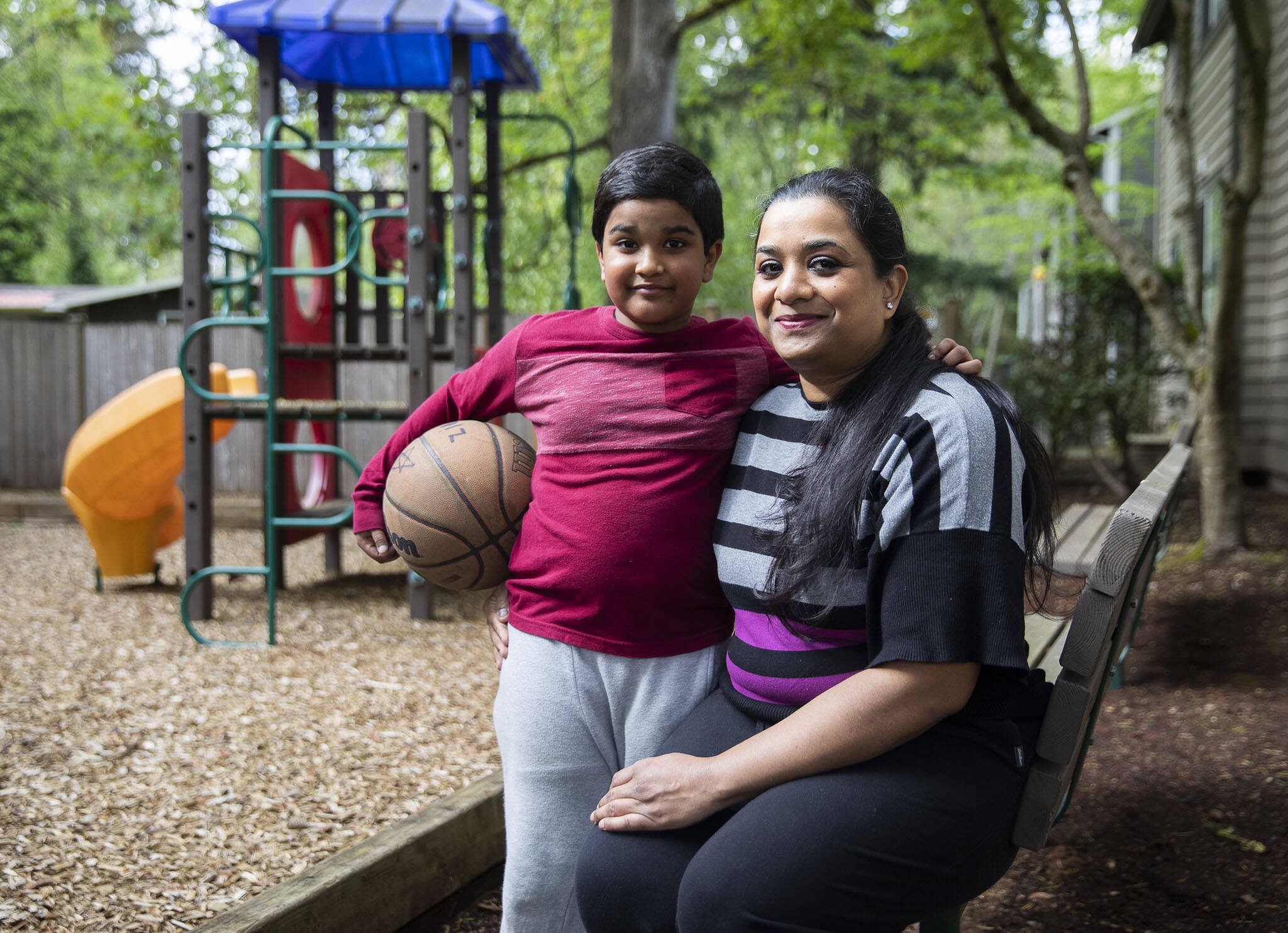 Anila Gill, right, and one of her sons Zion Gill, 8, at the apartment complex they live at on Friday, April 26, 2024 in Lynnwood, Washington. (Olivia Vanni / The Herald)