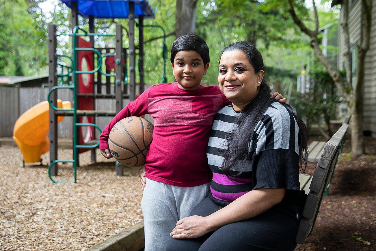 Anila Gill, right, and one of her sons Zion Gill, 8, at the apartment complex they live at on Friday, April 26, 2024 in Lynnwood, Washington. (Olivia Vanni / The Herald)