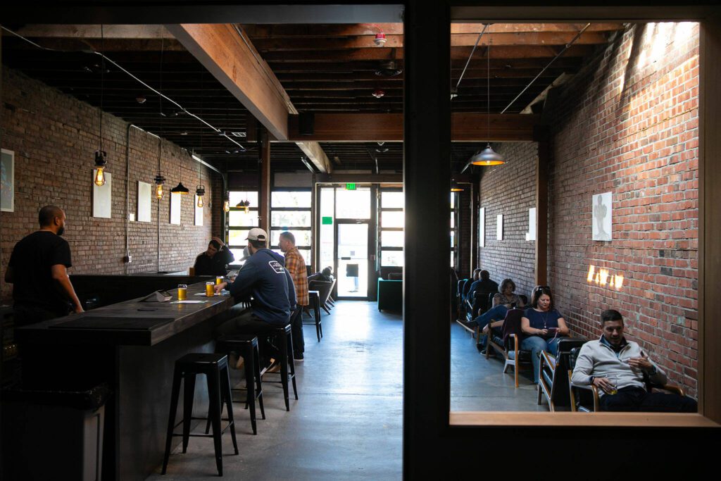 Laid back seating lines the walls at Obsidian Beer Hall on Friday, April 12, 2024, in downtown Everett, Washington. (Ryan Berry / The Herald) 
